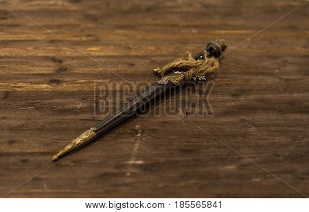 Ancient short sword dagger old knife on wooden background. defocused.