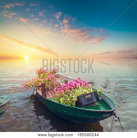 Famous Amsterdam with basket of colorful tulips against canal in Holland.