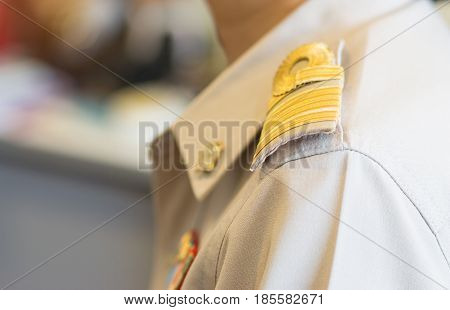 Thai teacher in formal officer government uniform with Brown suite and Golden stripe on shoulder thailand education