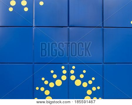 Background of Bright blue walls with large tiles and yellow spots