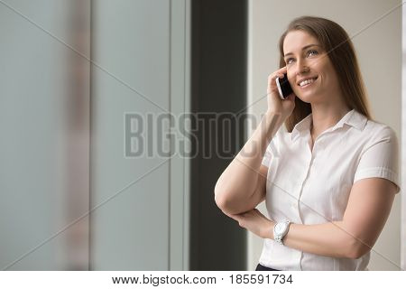 Smiling confident businesswoman talking on cellphone. Beautiful woman in formal wear calling from mobile phone. Female entrepreneur has pleasant business conversation, successful phone negotiations