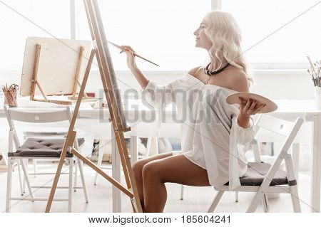 Inspired by the artist sitting in his bright Studio and paints with a brush on the easel