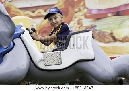 Cornwall, Quebec - July 26, 2014 - Wide view of a young boy enjoying a carnival fun ride at the Ribfest in Cornwall, Ontario on a sunny afternoon in July.