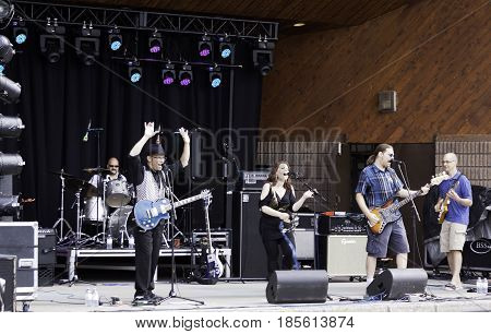 Cornwall, Quebec - July 26, 2014 -- Wide view of a band playing pop music at the Ribfest in Cornwall, Ontario on a sunny afternoon in July.