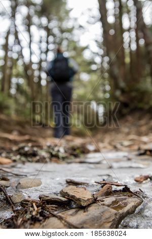 Hiker on Icy Trail with focus on foreground
