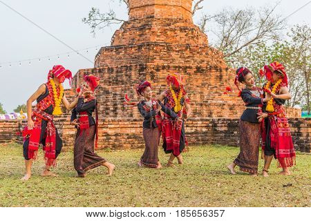 KALASIN THAILAND - FEBRUARY 20 2016: Girl and boy dancers with local dress doing Thai Northeastern traditional dance at Yaku Pagoda to celebrate Buddhism event in Kalasin
