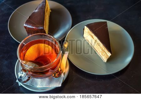 Close-up of morning cup of tea with cake inside cafe