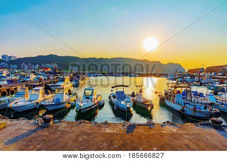 Boats docked in a small fishing town during sunset in Taiwan