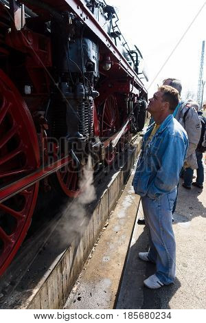 BERLIN - APRIL 21: Visitors and guests look at steam locomotive. Spring Festival Exhibition in the Rail yard Schoeneweide April 21 2013 in Berlin Germany