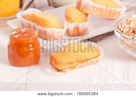Breakfast with plumcake and apricot jam on wooden table.