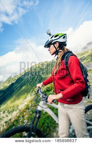 Mountainbiker with bike and Actioncam on Helmet.