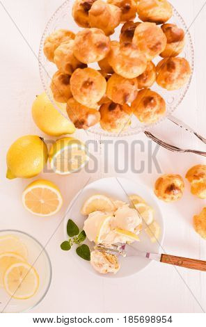 Lemon Profiteroles with custard cream on white dish.