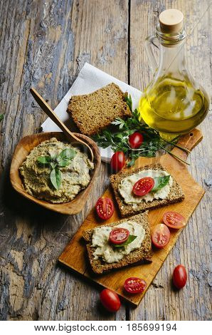 Mediterranean cuisine recipe. Hummus and baba ganush with homemade bread slices and cherytomatos on wooden table.