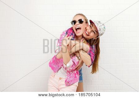 Fashion portrait of two friends posing. modern lifestyle. two stylish sexy hipster girls best friends ready for party. Two young girl friends standing together and having fun.