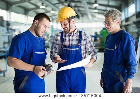 Engineer Teaching Apprentices To Use Computerized cnc metal processing machines in factory