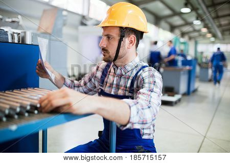 Supervisor doing quality control and pruduction check in metal factory