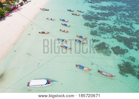 Aerial view over group of long tail boatsTop view from drone Koh Lipe island SatunThailand.