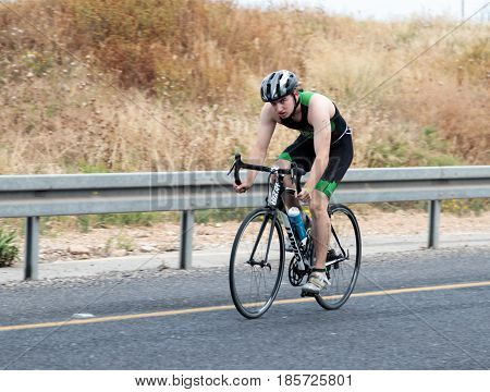 Nahariyya Israel - May 06 2017 : Participant of the annual triathlon competes in cycling on the route in Ahziv near Nahariyya Israel