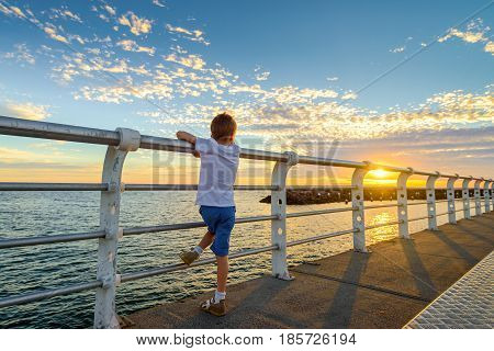 Boy watching sunset from St. Kilda Jetty Melbourne Victoria Australia