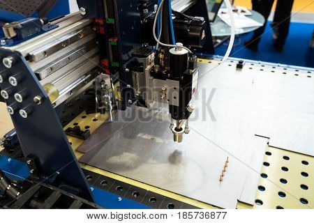 Compact stud welding head, metal processing background. Fully automatic welding process on steel or aluminium material