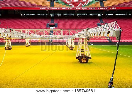 Amsterdam, Netherlands - April, 2017: Interior view of Amsterdam Ajax Football Arena. System of care and sprinkling of the lawn grass at the stadium