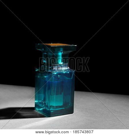 Bottle of modern male perfume on dark background