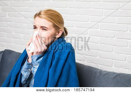 Pretty Blonde Sneezing In The Living-room At Home