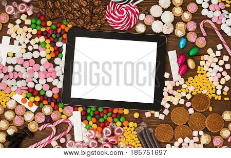 Blank screen Tablet computer and candy on table
