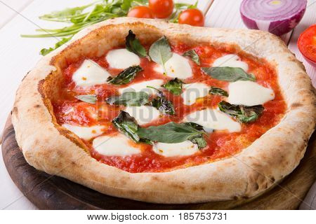 Whole neapolitan pizza served on wooden board