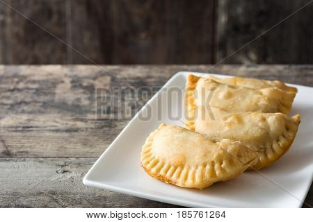 Delicious typical Spanish empanadas on wooden table