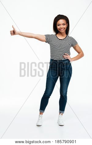 Full length portrait of a happy cheerful african woman showing thumbs up gesture isolated over white background