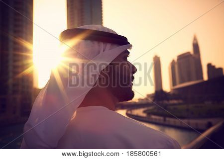 Arab man with kandura enjoying sunrise in Dubai proud of his country