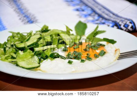 Appetizing scrambled eggs with cabbage salad on a white plate