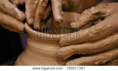 Potter is making clay pot bowl or vase ceramics porcelain on the potter's wheel. Creating pottery art and handicraft modelling creation.