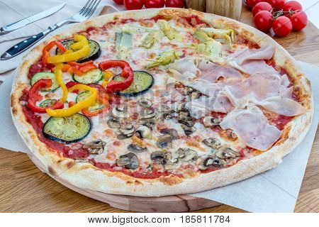 Italian four seasons pizza with vegetables, ham and mushrooms