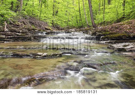 Fall Creek a small but beautiful stream in Putnam County Indiana flows over rocky ledges through the woods in spring.