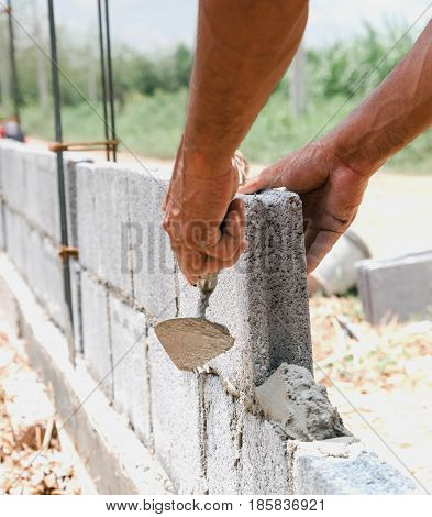 bricklayer installing bricks Masonry work in construction site