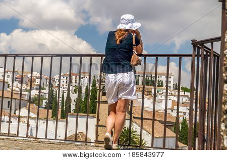 view of young women looking at city of ronda from a balcony spain