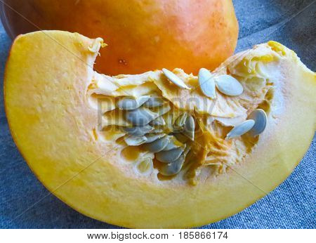 Pieces of cut pumpkin with seeds on the table.
