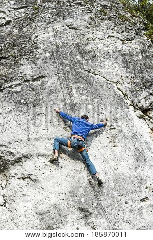 Podlesice Poland april 30 2017: Young male climber climbing a route on a rock. Jura krakowsko chestochowska.
