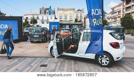 Sables d Olonne France - May 07 2017 : Dacia Tour 2017 is a commercial operation organized by the car builder in order to present its cars throughout France - A young man watching a car