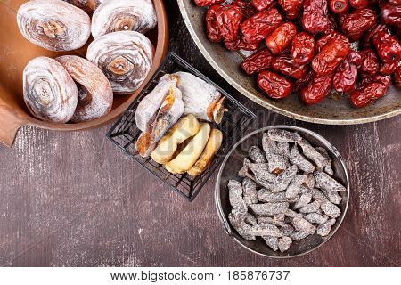Dried fruits - persimmon figs red dates or jujube and salted sliced plum. Top view.