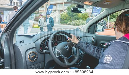 Sables d Olonne France - May 07 2017 : Dacia Tour 2017 is a commercial operation organized by the car builder in order to present its cars throughout France - A woman watching a car