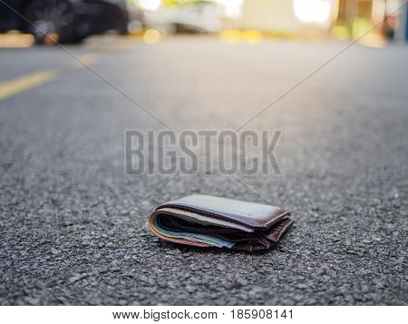 wallet with money drop on the street lost money concept copy space on top