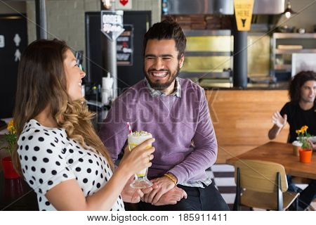 Happy friends looking at rach other at counter in restaurant