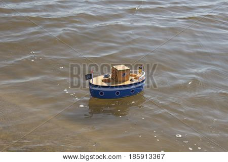 Toy ship floats in water. Returned to the shore
