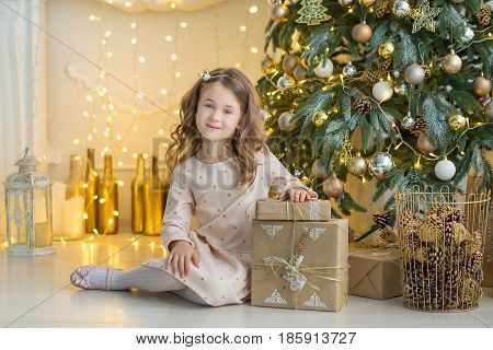 Family on Christmas eve at fireplace. Kids opening Xmas presents. Children under Christmas tree with gift boxes. Decorated living room with traditional fire place. Cozy warm winter evening at home