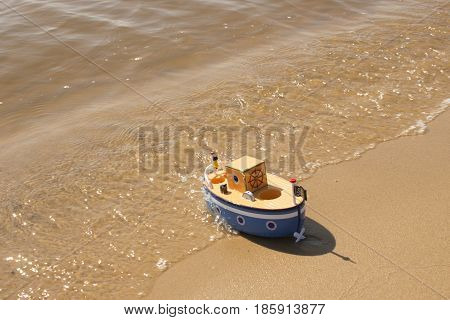 Toy ship floats in water. Returned to the shore