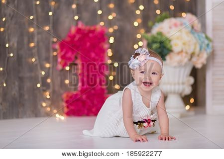 Cute baby girl 1-2 year old sitting on floor with pink balloons in room over white. Isolated. Birthday party. Celebration. Happy birthday baby, Little girl with group ball. Play room