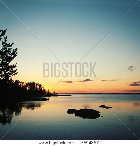 Wild nature of Russian North. Vintage photo. Beautiful northern landscape. Ladoga lake at sunset. Aged photo in retro style. Island of Valaam Republic of Karelia Russia.